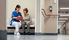 Eine Seniorin lässt sich nach den Anzeichen eines Schlaganfalls von einer Ärztin über eine Behandlung beraten.