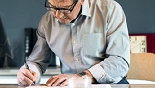 Seniorin trägt Armband mit Funksender: Ein Hausnotrufsystem kann älteren Frauen bei einem möglichen Herzinfarkt das Leben retten.