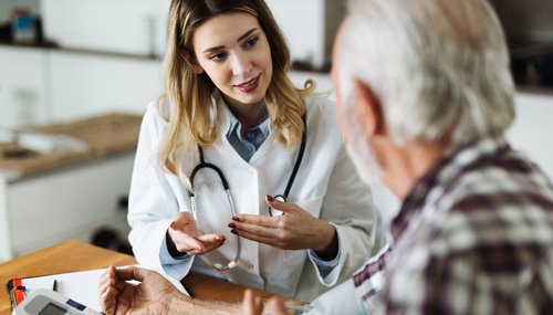 Seniorin trägt Armband mit Funksender: Ein Hausnotrufsystem kann älteren Frauen bei einem möglichen Herzinfarkt das Leben retten.