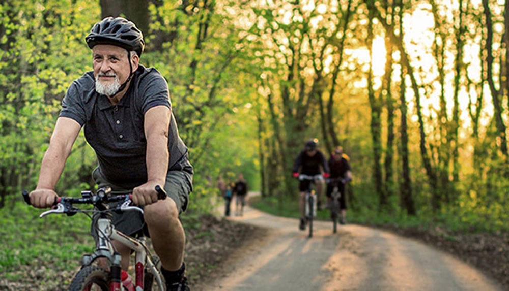 Mann fährt Fahrrad, um das Cholesterin zu senken.